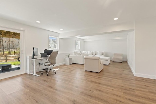 living area featuring recessed lighting, baseboards, and light wood-style floors