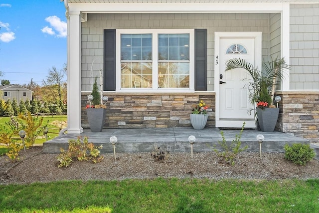entrance to property with covered porch and stone siding