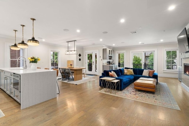 654 E 7th Unit 3, Boston, MA 02127 - living room with crown molding, recessed lighting, a glass covered fireplace, light wood finished floors, and baseboards
