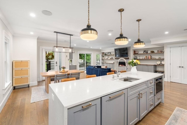 654 E 7th Unit 3, Boston, MA 02127 - kitchen with a sink, gray cabinets, light countertops, crown molding, and an island with sink