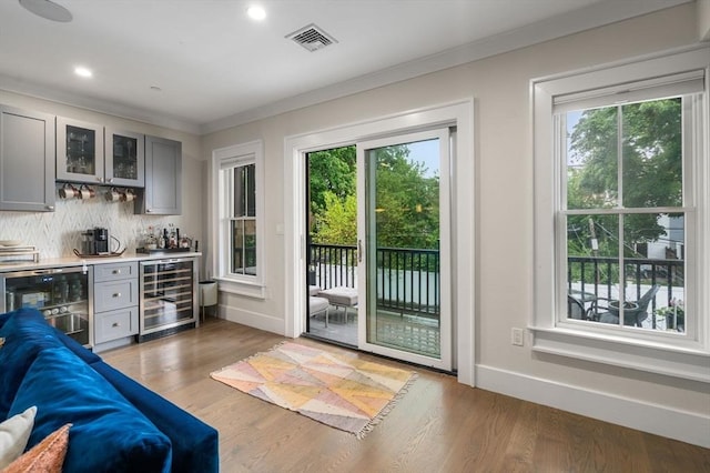 654 E 7th Unit 3, Boston, MA 02127 - entryway featuring wine cooler, a dry bar, ornamental molding, wood finished floors, and recessed lighting