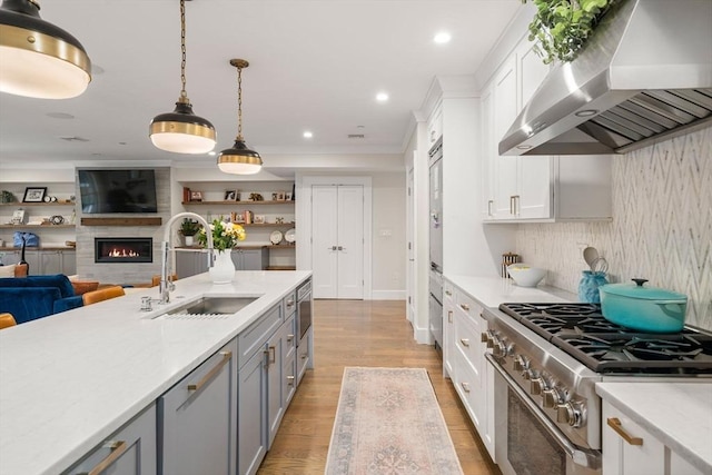 654 E 7th Unit 3, Boston, MA 02127 - kitchen featuring high end range, extractor fan, a sink, white cabinets, and open floor plan