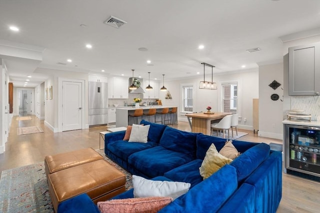 654 E 7th Unit 3, Boston, MA 02127 - living room with wine cooler, ornamental molding, recessed lighting, light wood-style floors, and baseboards