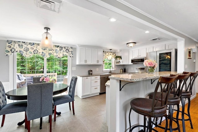 4 Jester Way, Plymouth, MA 02360 - kitchen featuring stainless steel appliances, plenty of natural light, white cabinets, a kitchen bar, and crown molding