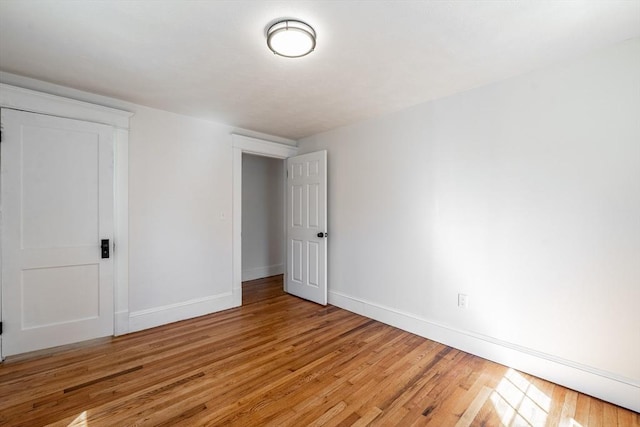 unfurnished room featuring baseboards and light wood-style floors