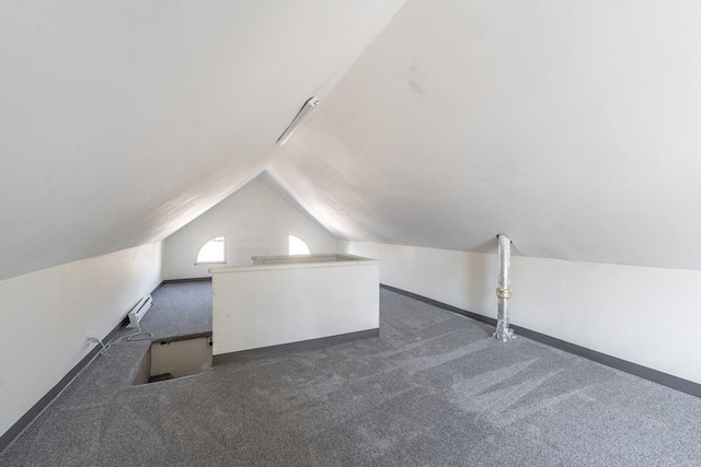 additional living space featuring a wall mounted air conditioner, baseboards, lofted ceiling, and carpet