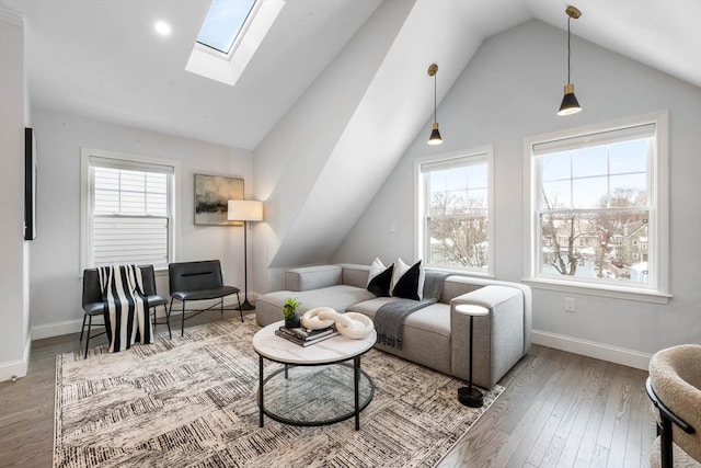 living room with hardwood / wood-style floors and vaulted ceiling with skylight