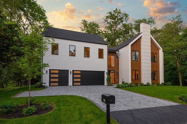 48 Sherburne Rd, Lexington, MA 02421 - view of front facade featuring an attached garage, decorative driveway, a yard, and a chimney