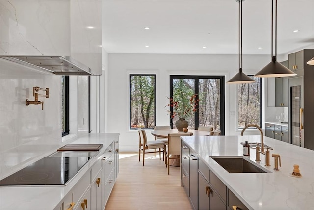 48 Sherburne Rd, Lexington, MA 02421 - kitchen with exhaust hood, a sink, black electric stovetop, light wood-style floors, and recessed lighting