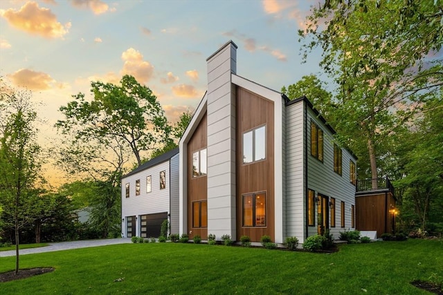 48 Sherburne Rd, Lexington, MA 02421 - view of front facade featuring an attached garage, a front lawn, driveway, and a chimney