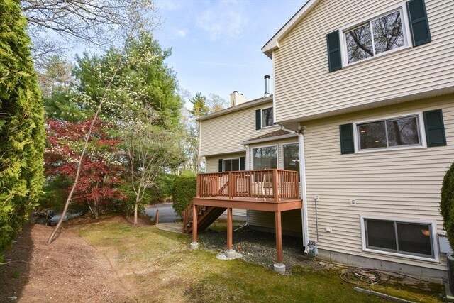 back of house featuring a yard, a wooden deck, and stairs