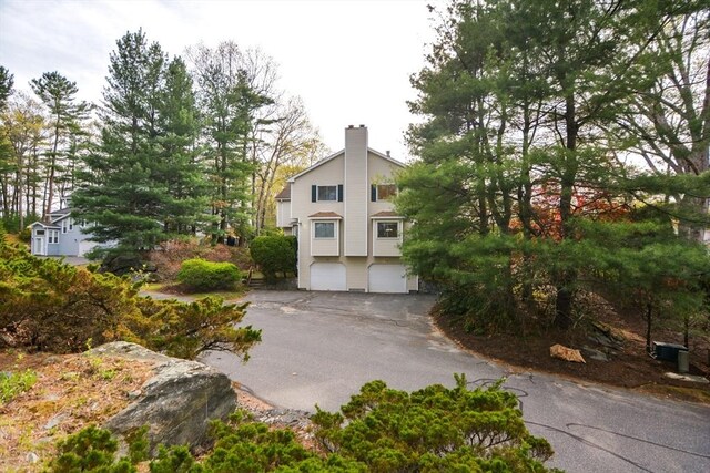 exterior space with an attached garage and a chimney
