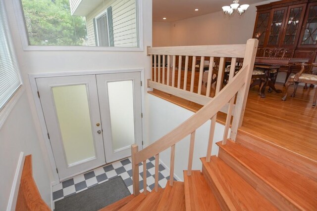 stairs featuring french doors and a chandelier