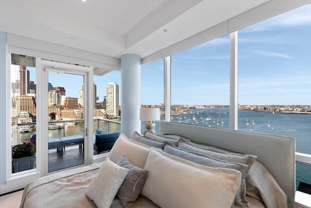 sunroom featuring a city view and a water view