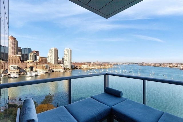 balcony featuring a water view and a skyline view