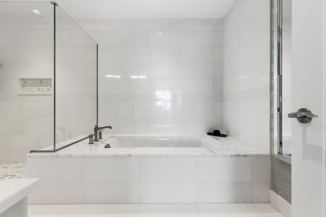 full bathroom featuring a garden tub and tile walls