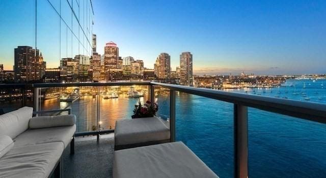 balcony featuring a view of skyline, a water view, and outdoor lounge area