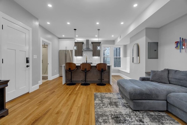 living room featuring sink, light wood-type flooring, and electric panel