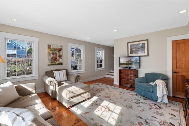 living room featuring baseboards, stairs, recessed lighting, and wood finished floors