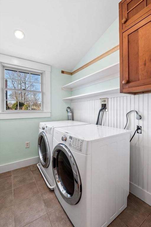 washroom featuring cabinet space, washing machine and clothes dryer, baseboards, and light tile patterned flooring
