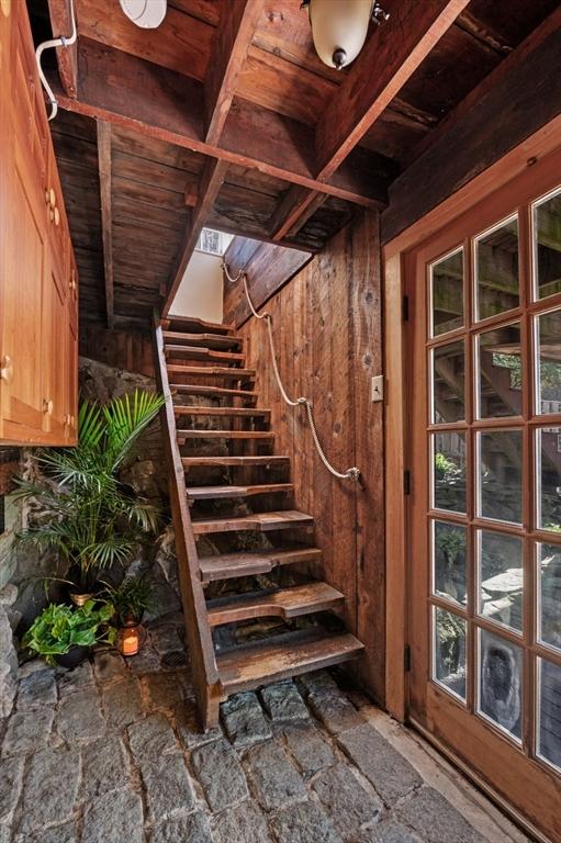 staircase featuring wooden walls