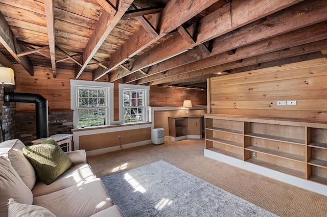 carpeted living room featuring a wood stove, wood ceiling, wood walls, and beamed ceiling