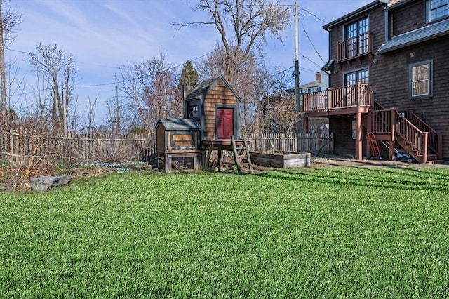 view of yard featuring a deck, stairway, an outdoor structure, and a fenced backyard