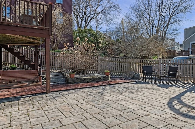 view of patio featuring stairway and fence
