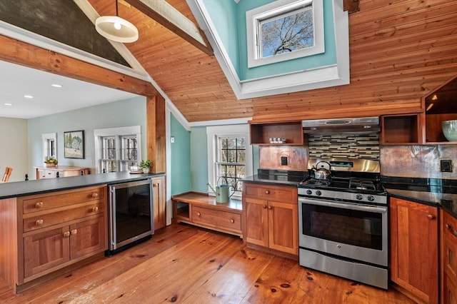 kitchen with stainless steel gas range, open shelves, dark countertops, and beverage cooler
