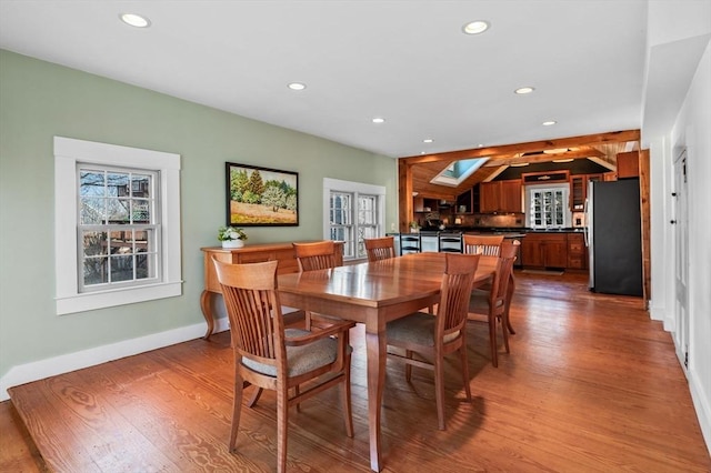 dining room featuring wood finished floors, a healthy amount of sunlight, and recessed lighting