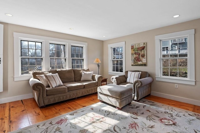 living room with light wood finished floors, baseboards, and recessed lighting