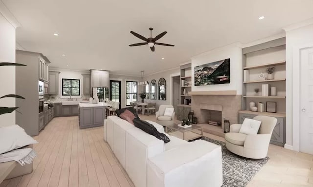 living room featuring light hardwood / wood-style flooring, ceiling fan, and ornamental molding