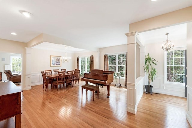40 Canoe Lndg, Plymouth, MA 02360 - dining area featuring a chandelier, a decorative wall, light wood-style floors, decorative columns, and a wainscoted wall