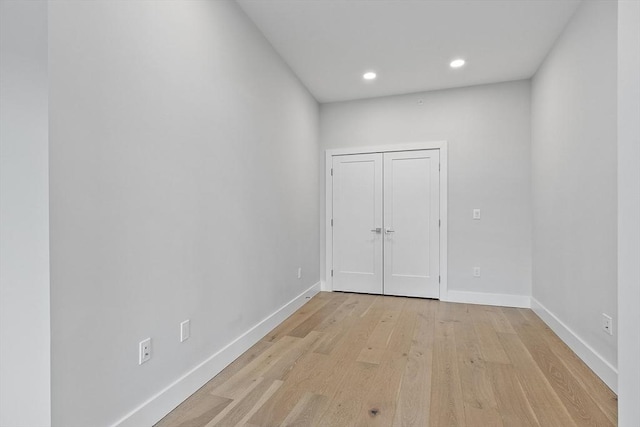 empty room featuring recessed lighting, baseboards, and light wood-style floors