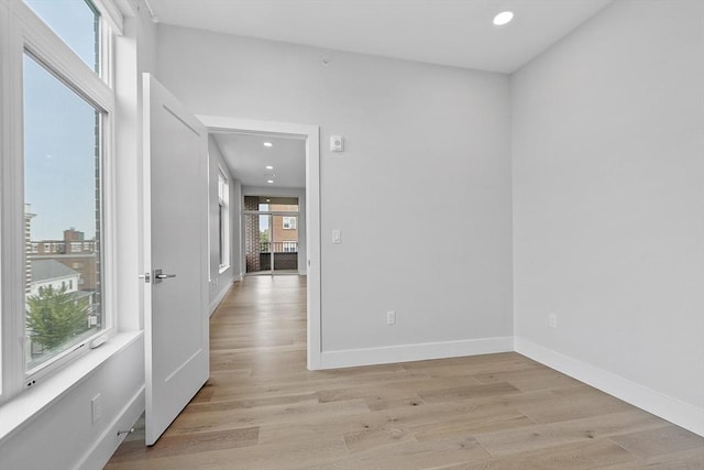 empty room with recessed lighting, baseboards, and light wood-type flooring