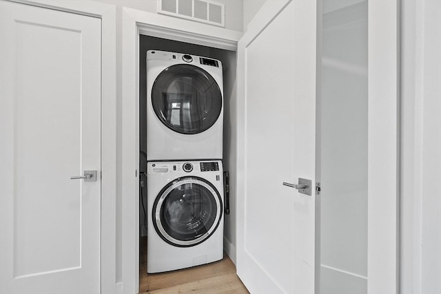 laundry room featuring visible vents, light wood-style flooring, laundry area, and stacked washer / dryer