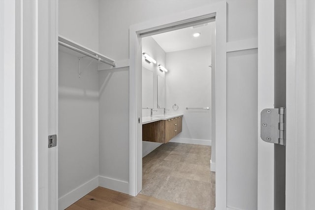 interior space featuring light wood-style floors, baseboards, and a sink