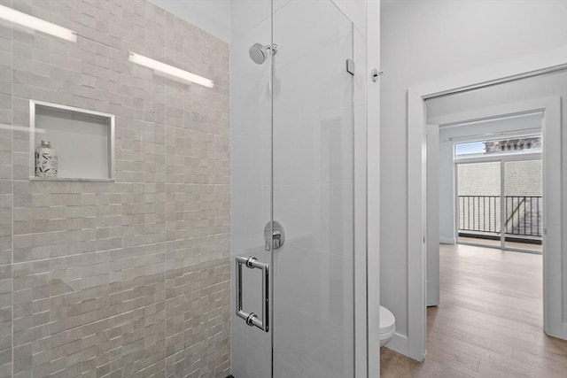 bathroom featuring a shower stall and toilet