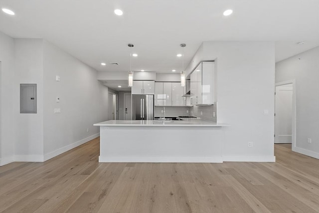 kitchen with light wood-type flooring, high end fridge, electric panel, white cabinets, and light countertops