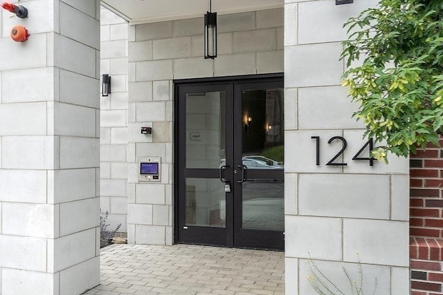 entrance to property featuring french doors and concrete block siding