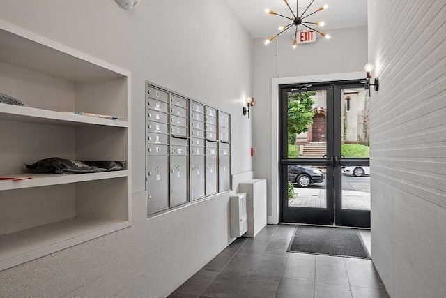 tiled foyer entrance with french doors and an inviting chandelier