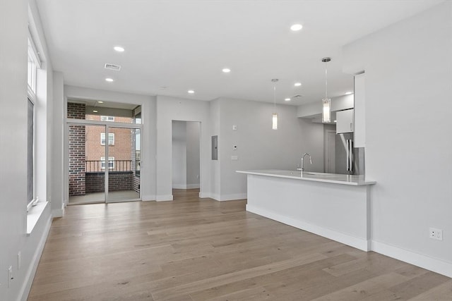 unfurnished living room featuring recessed lighting, a healthy amount of sunlight, visible vents, and light wood-type flooring