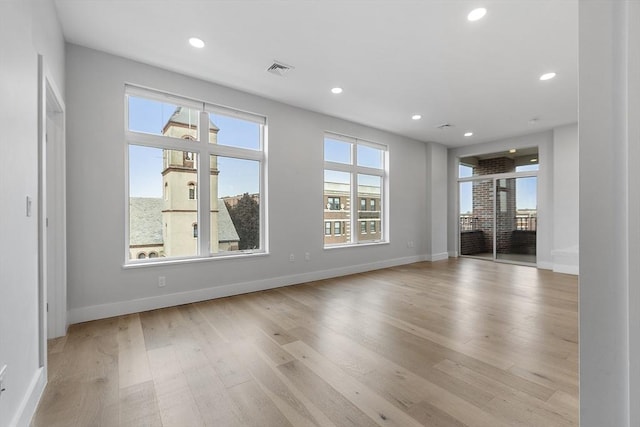 unfurnished living room featuring visible vents, recessed lighting, light wood-type flooring, and baseboards