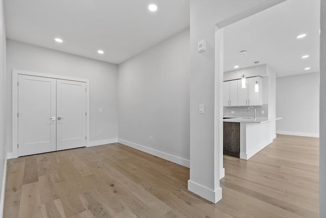 foyer featuring light wood-style flooring, recessed lighting, and baseboards