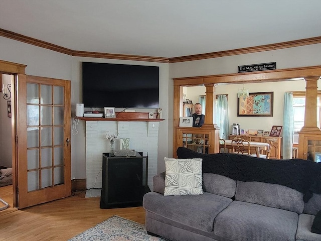 living room featuring decorative columns, ornamental molding, and parquet flooring