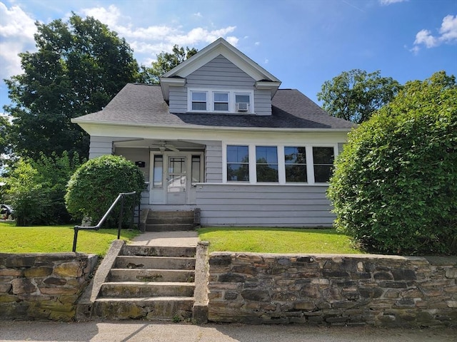 bungalow-style home with a shingled roof and a front yard