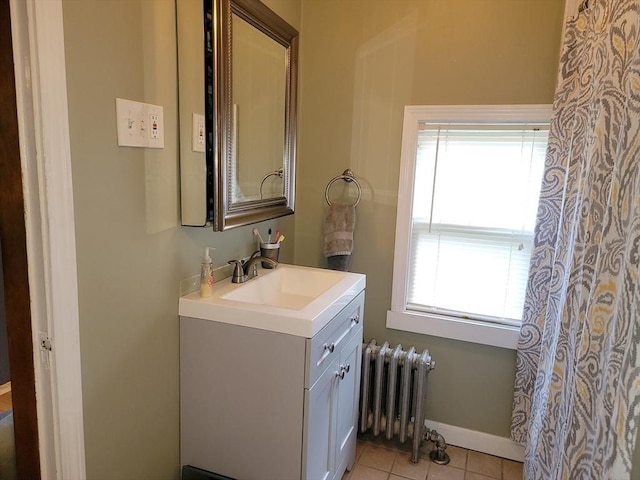 bathroom with tile patterned floors, baseboards, vanity, and radiator heating unit