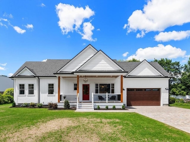 28 Marlboro Rd, Woburn, MA 01801 - modern farmhouse style home with a porch, an attached garage, decorative driveway, a front lawn, and a shingled roof