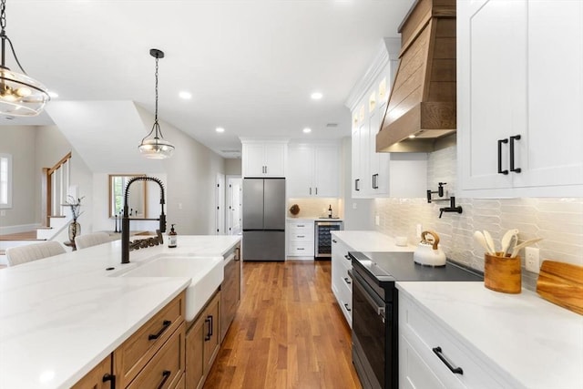 28 Marlboro Rd, Woburn, MA 01801 - kitchen featuring stainless steel fridge, black range with electric cooktop, beverage cooler, custom exhaust hood, and a sink