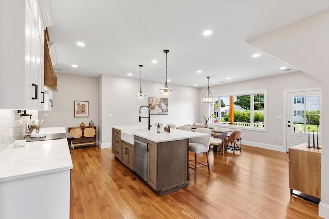28 Marlboro Rd, Woburn, MA 01801 - kitchen with a sink, dishwasher, a breakfast bar, baseboards, and recessed lighting